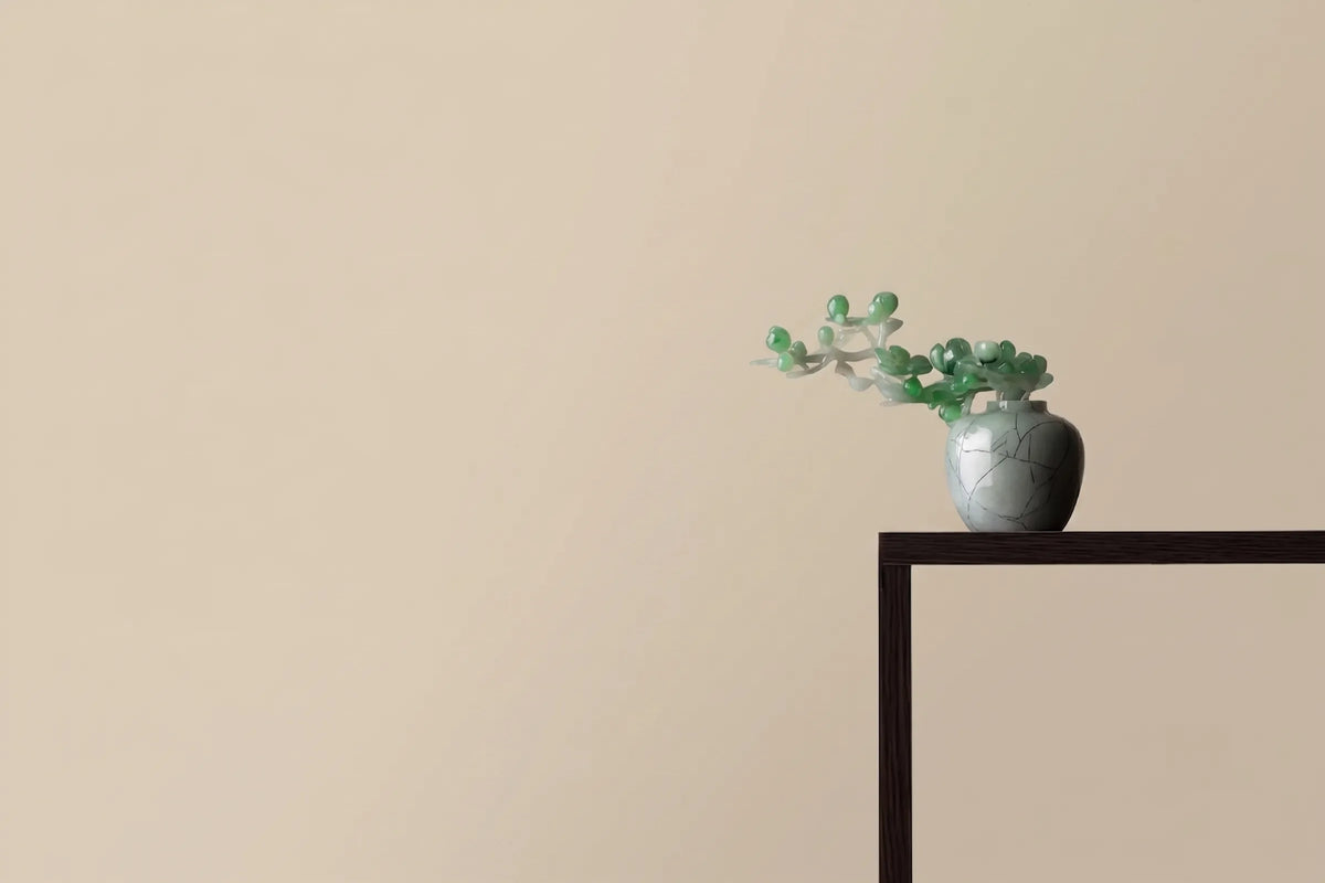 Jade bonsai in a celadon vase on a dark wood console